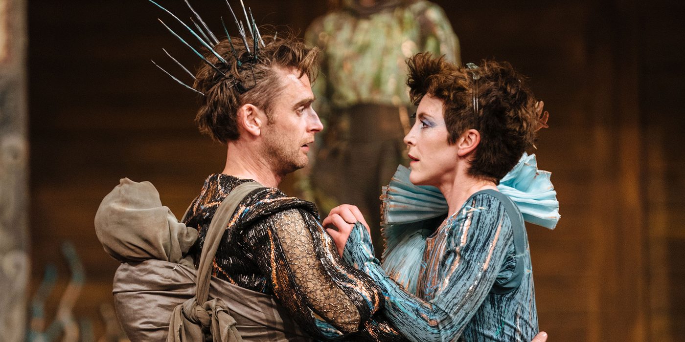 A Midsummer Night's Dream 2023 Two actors holding each other, they are both in heavy, fantastical costumes