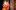 Lydia Fleming as Hero and Adam Wadsworth as Claudio wearing orange Elizabethan-style dress and kissing each other in Much Ado About Nothing at Shakespeare's Globe.